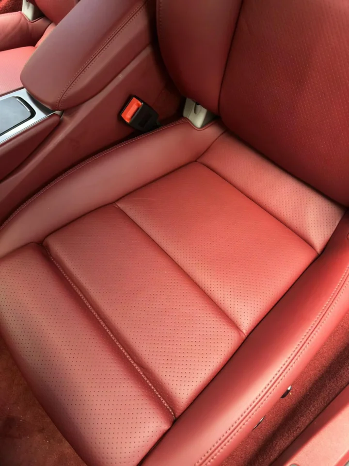Rich burgundy leather car seat with a restored finish